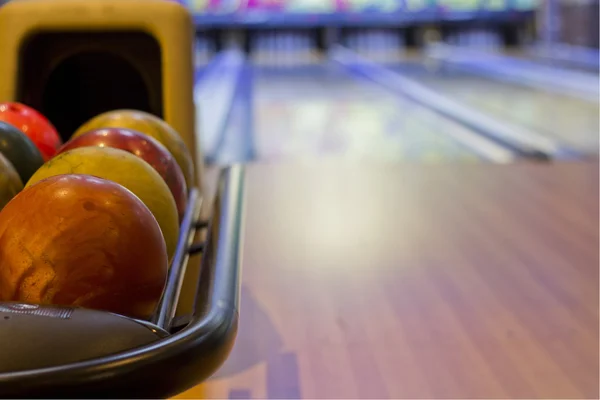 Palle da bowling colorate di fronte a tenpin vicolo — Foto Stock