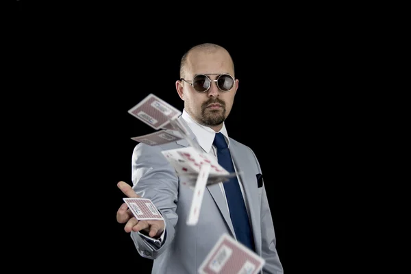 Man throwing playing cards up in the air isolated on black background — Stock Photo, Image