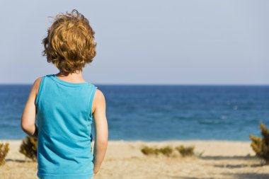 şirin Kızıl saçlı çocuk sahilde denize bakan