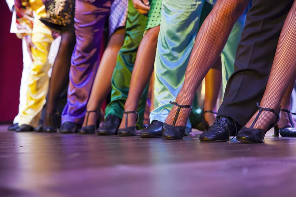 Pernas dançarinas se apresentando no palco em trajes coloridos — Fotografia de Stock