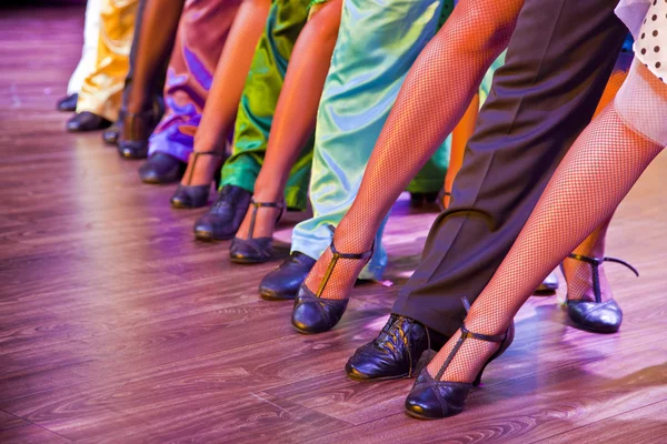 Danser benen uitvoeren op het podium in kleurrijke kostuums — Stockfoto