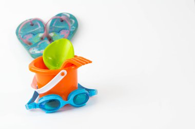 Yaz oyuncakları spade gözlük ile flip flop beyaz arka plan üzerinde izole kova.