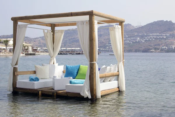 Pérgola blanca cojines y cortinas en el mar romántico —  Fotos de Stock