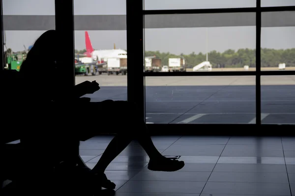 Silhueta mulher à espera de avião no aeroporto — Fotografia de Stock