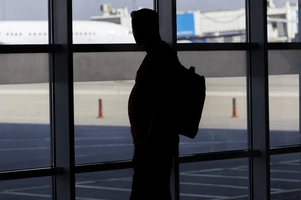 Silhueta homem esperando por avião de embarque no aeroporto — Fotografia de Stock