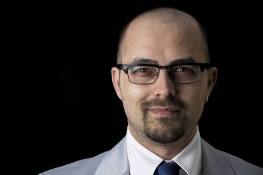 Takım elbise ve siyah arka plan üzerine izole gözlük yakışıklı iş adamı