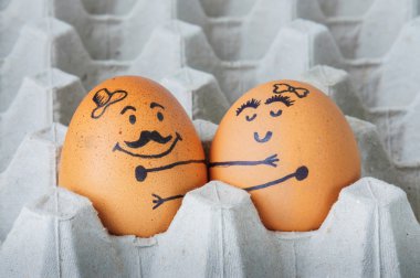Two  eggs hugging couple arranged in carton