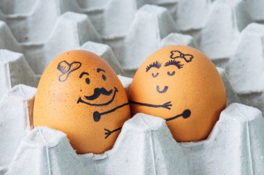 Two eggs hugging  arranged in carton