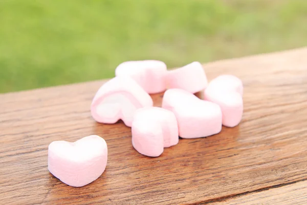 Heart pink marshmallow on wood background.
