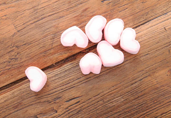 sweet heart shape of marshmallows on old wood background.