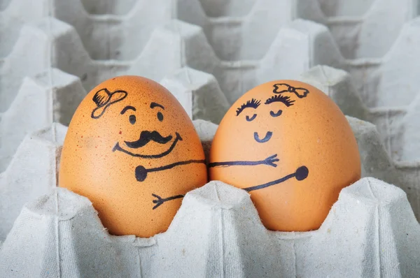 Two  eggs hugging couple arranged in carton — Stock Fotó