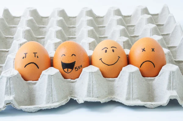 four brown eggs  with faces drawn  