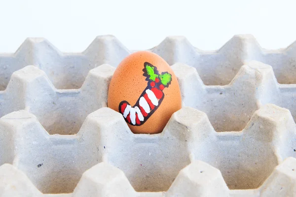 Christmas egg with faces drawn arranged in carton