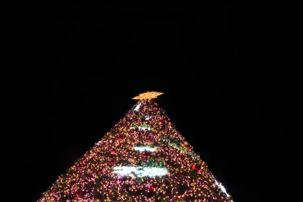 Рождественская елка с разноцветными огнями ночью — стоковое фото