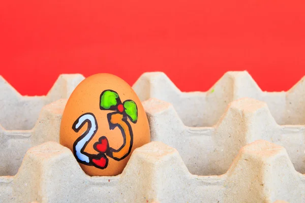Karácsonyi tojás arcot rajzolt rendezett karton a piros backgro — Stock Fotó
