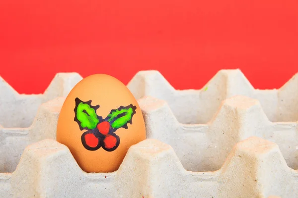 Christmas egg with faces drawn arranged in carton on red backgro — Stock Photo, Image