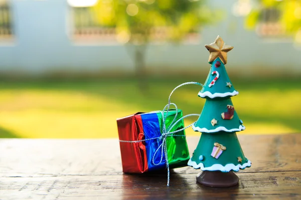 Bahçe arka planda ahşap masa üzerinde Noel ağacı ile hediye