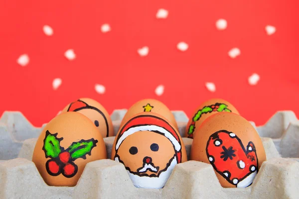 Christmas egg with faces drawn arranged in carton on snow backgr — Stock Photo, Image