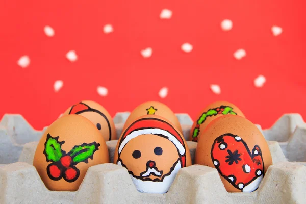 Yüzü çizilmiş olan Noel yumurta karton kar backgr tarihinde düzenlenen