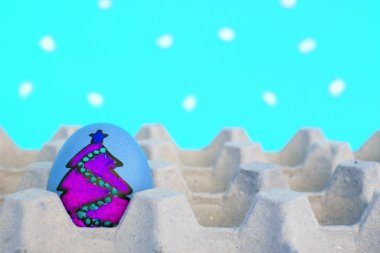 Yüzü çizilmiş olan Noel yumurta karton kar backgr tarihinde düzenlenen