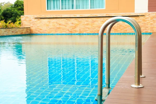 Una refrescante piscina azul con escalera en condominio —  Fotos de Stock