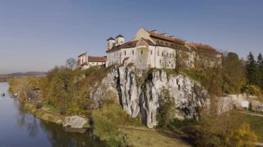 Tyniec Abbey 'in eğik ve geri çekilen hava aracı görüntüleri. Tarihi manastır ve sonbahar manzarası yavaş yavaş gözler önüne serilerek sinematik ve manzaralı bir manzara yaratır. Seyahat, tarih, kültür için ideal.