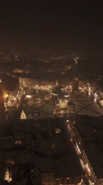 Noel boyunca karlı Krakow Pazar Meydanı üzerinde kış uçağı dikey uçuşu.