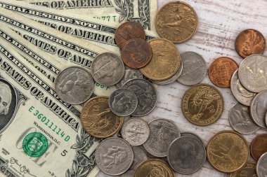 Tahta masanın üzerinde bozuk para senti olan 1 dolarlık banknotlar. Aynı para kavramı