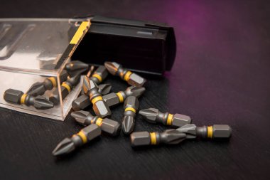 Siyah masa tornavidasına dağılmış metal parçalar. Hepsi tamir için.