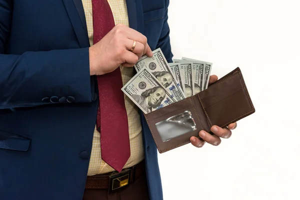 Businessman in suit gets us money from the wallet, isolated. Male hands holding a black leather wallet with US Dollars cash inside. Business, finances and money concept