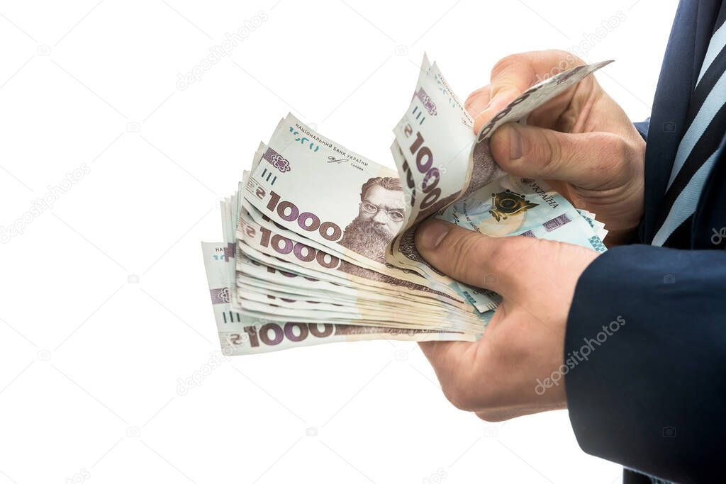 businessman made huge profits, showing a lot of money. a man in a suit holds a pack of new banktons of Ukraine. 1000 hryvnia