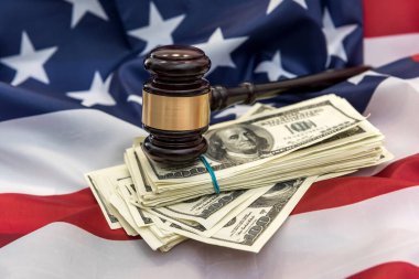Amerika bayrağının üzerinde kelepçe ve dolar banknotları olan yargıç tokmağı. Hukuk ya da suç kavramı. Adalet