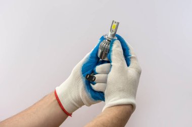 Elinde koruyucu eldiven, elinde halojen lamba, izole edilmiş.