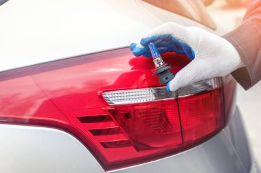 Adam yeni modern halojen otomobil ampulünü tamir için tutuyor. otomotiv ekipmanı