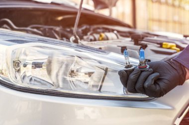 Yeni modern halojen odaklı araba farı ampulü yerleştiriliyor. mekanik tutuş otomatik lamba