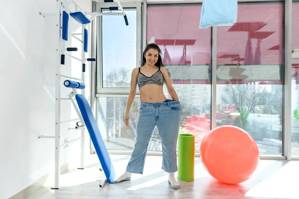 Kvinna Överdimensionerade Jeans Poserar Gym — Stockfoto