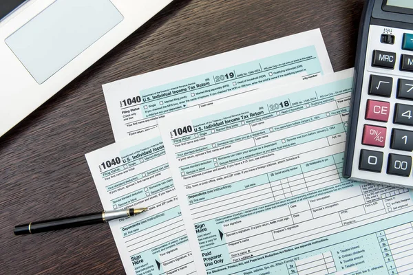 Tax form, pen and calculator at office desk. financial accountig