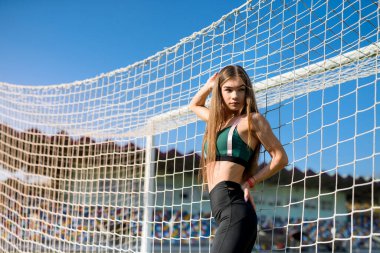 Spor yaptıktan ya da stadyumda koştuktan sonra dinlenen genç bir kadının portresi. Fitness ve sağlıklı yaşam tarzı konsepti