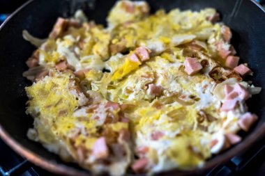Kızarmış yumurta sosis parçaları ve sıcak tavada soğan. Ev yapımı omlet.