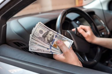 İş adamı bir ürün ya da hizmet için ödeme yapar, arabada otururken dolar verir. finans kavramı