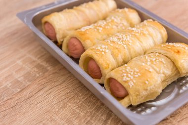 Hamurda pişmiş lezzetli rulo sosisler. Taze ev yapımı aperatif