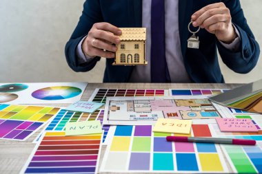 Erkek el, iç perspektife sahip renk örneklerini tutuyor. Daire çizimi, malzeme ve renk örnekleriyle çalışan iç mimar eli.