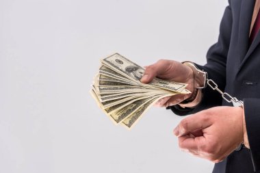 Rüşvet ya da yolsuzluk kavramı erkeklerin elinde dolarları kelepçeler. suçlu