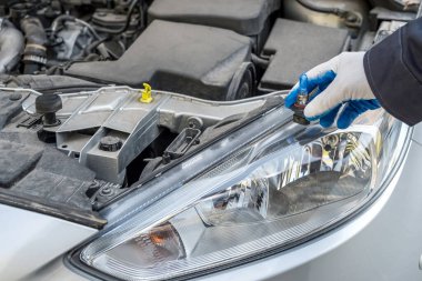Adam yeni modern halojen otomobil ampulünü tamir için tutuyor. otomotiv ekipmanı