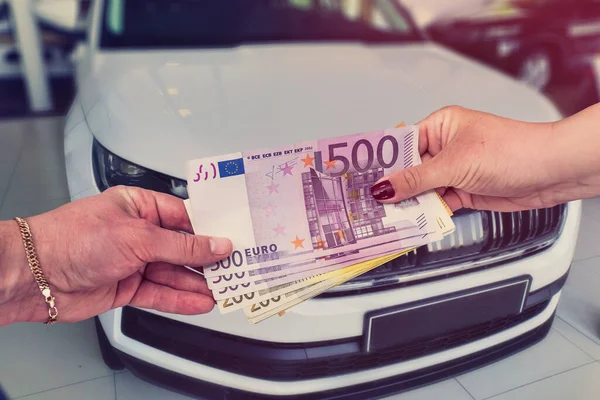 the customer pays euro banknotes for his dream - a new car.
