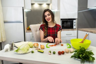 Tatlı kız sağlıklı bir yaşam için farklı sebze ve sebzelerden oluşan bir salata hazırlıyor.