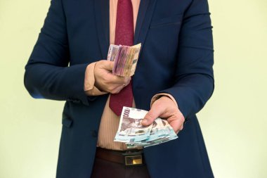 Erkek eller yeşilde izole edilmiş Ukrayna Hryvnia banknotlarını tutuyor. Hryvnia 'nın yeni 1000 500' ü ve 200 'ü nakit. Para kavramı kaydet