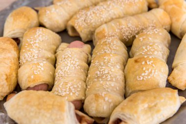 Hamurda pişmiş lezzetli rulo sosisler. Taze ev yapımı aperatif