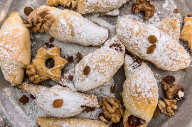 Lezzetli pişmiş ve üzerine pudra şekerli simit ve çörek serpiştirilmiş. Ev yapımı tatlı tatlı.