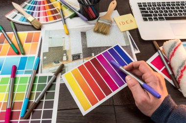 Tasarım evi için renk örnekleyici ile erkek el işi. Daire çizimi ofis masasında. 